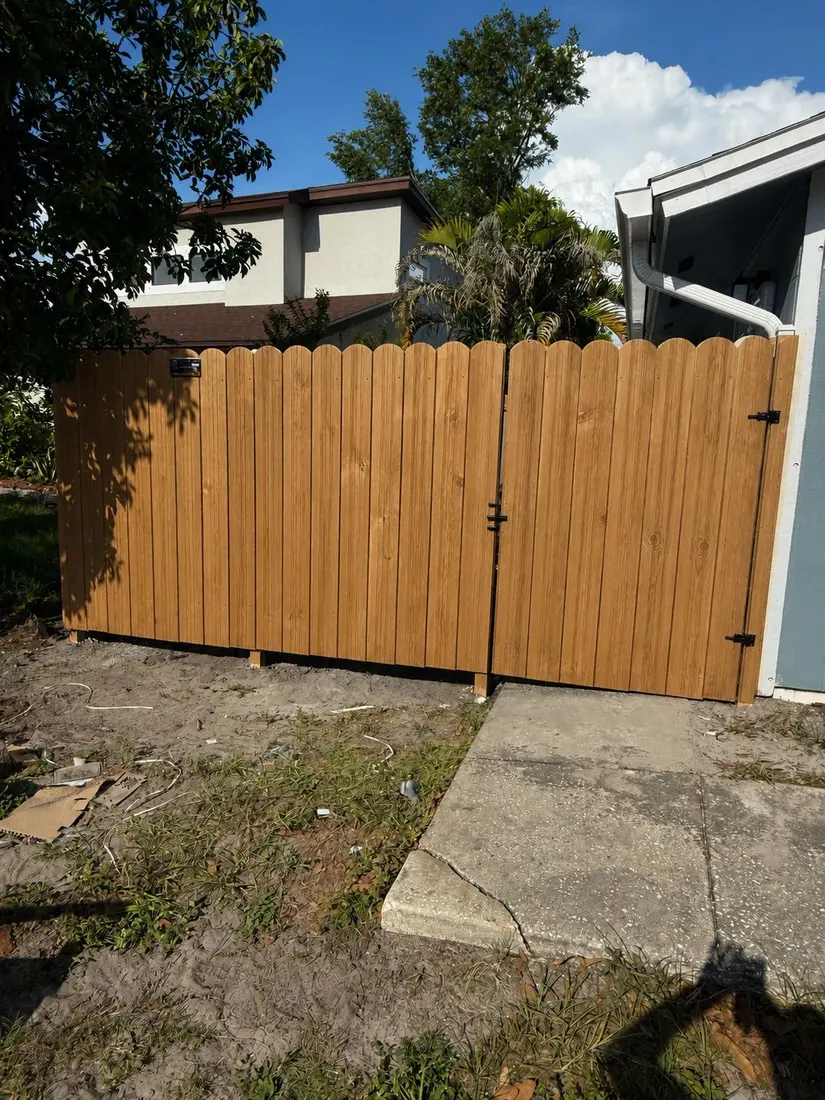 Wood privacy fence and gate beside a Florida home