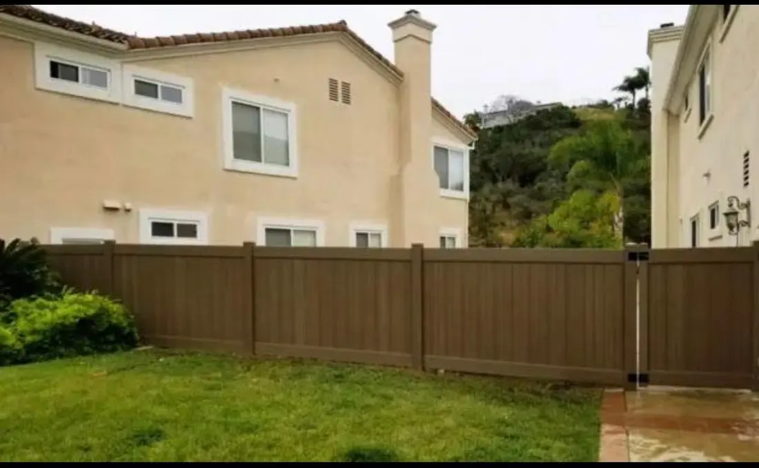 Wood-grain vinyl privacy fence and gate