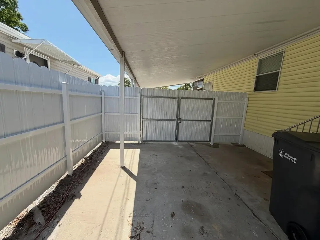 White vinyl gate installed under a carport