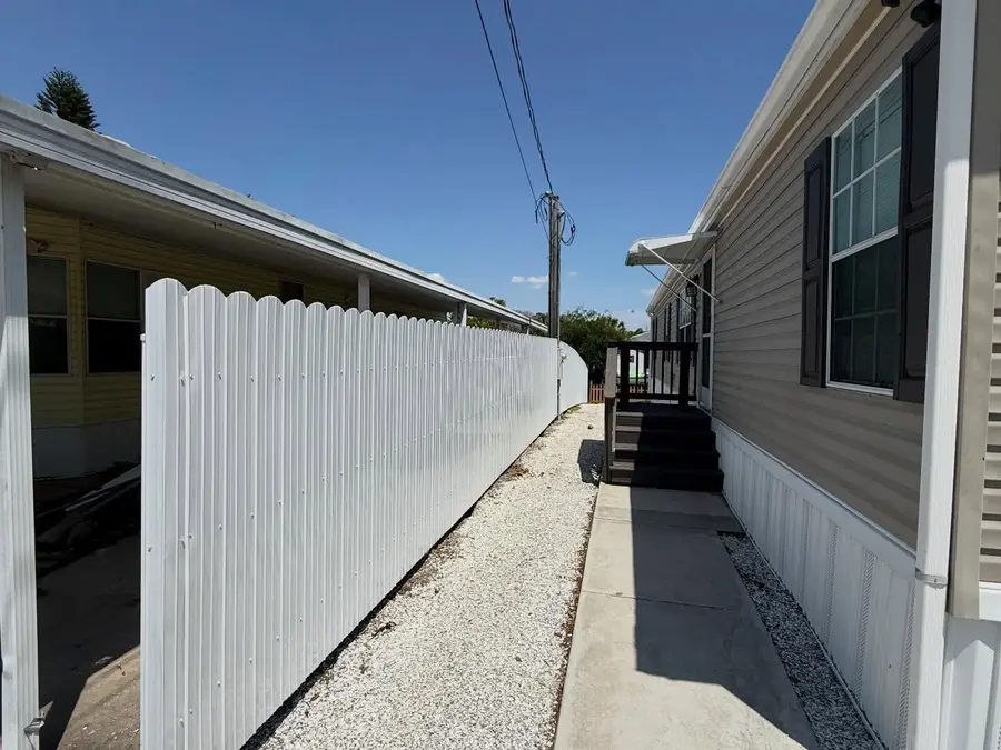 Fence company Vero Beach, FL β white vinyl fence along a side-yard walkway
